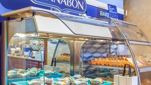 Vitrine de pastelaria com doces e um letreiro que diz "CINNABON".