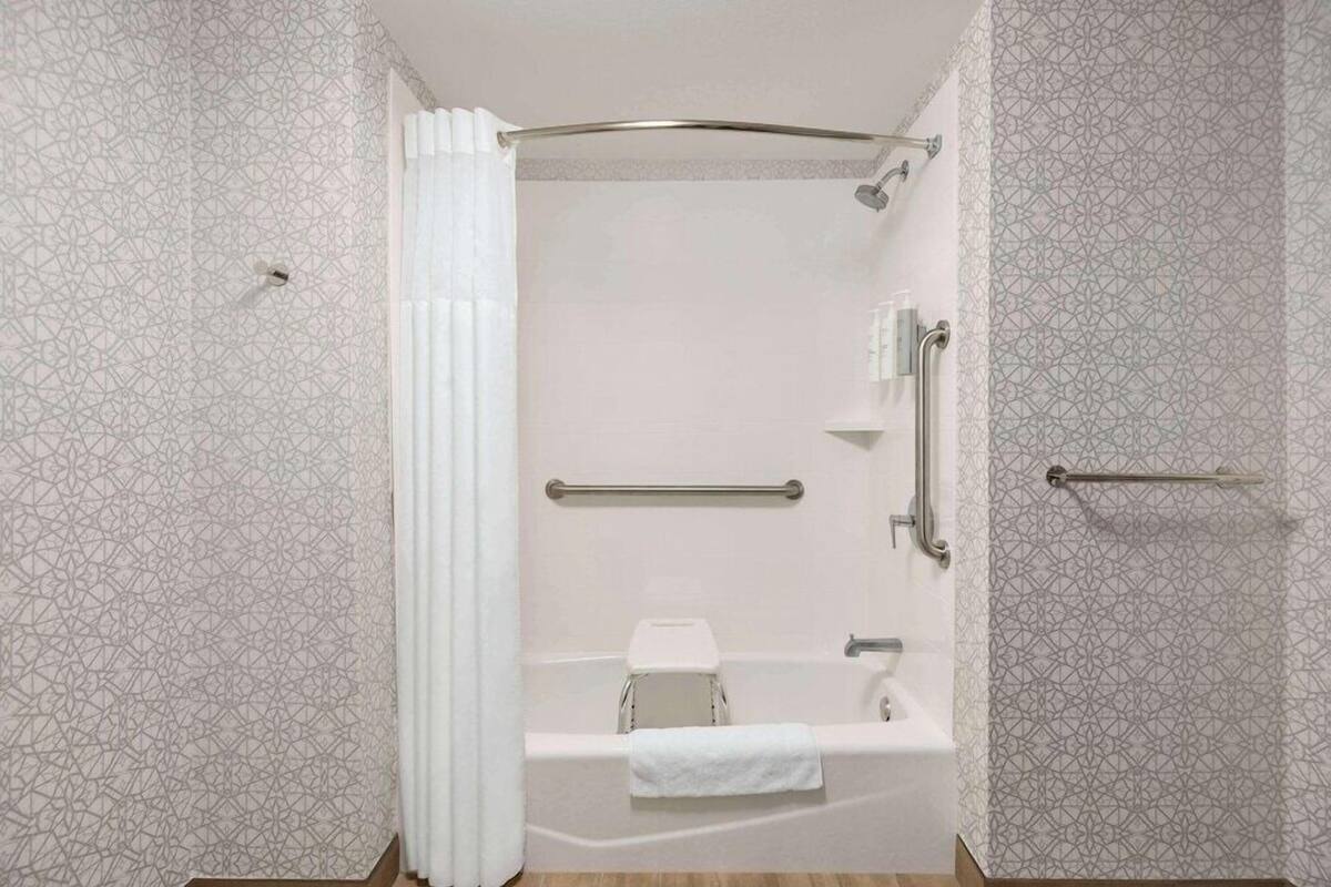 A modern bathroom with a shower, a toilet, and a bathtub.
