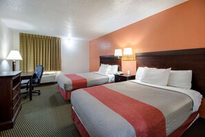 Two single beds with striped bedspreads, a desk, chair, and telephone.