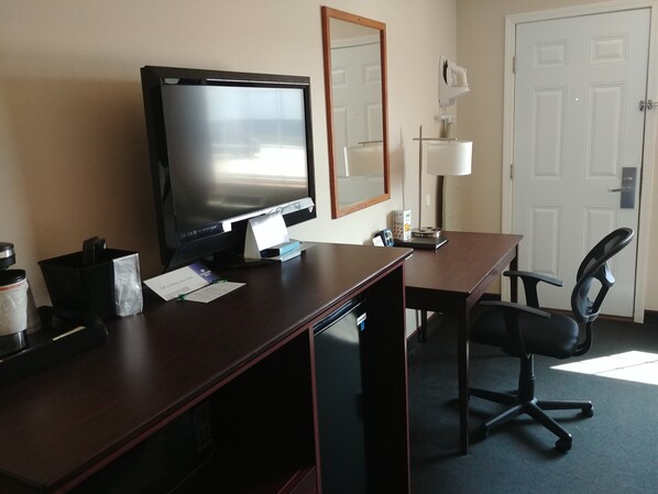 Work in comfort with a dedicated workspace featuring a desk, chair, and lamp.