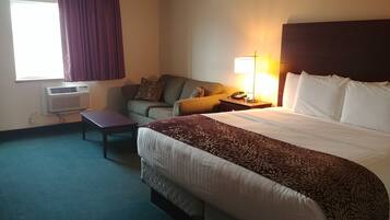 Una habitación de hotel con una cama, un sofá, un escritorio y una lámpara.