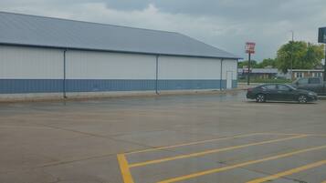 A large industrial building with a flat roof and a parking lot with yellow lines.