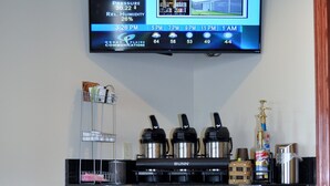 A kitchen area with a coffee maker, a Bunn coffee machine, a bottle of hand sanitizer, and a trash can. - Boarders Inn & Suites by Cobblestone Hotels – Broken Bow (Broken Bow)