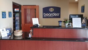 A reception desk at Boarders Inn & Suites with a sign indicating check-in and check-out times, a welcome sign, a directory, and a credit card advisory notice. - Boarders Inn & Suites by Cobblestone Hotels – Broken Bow (Broken Bow)