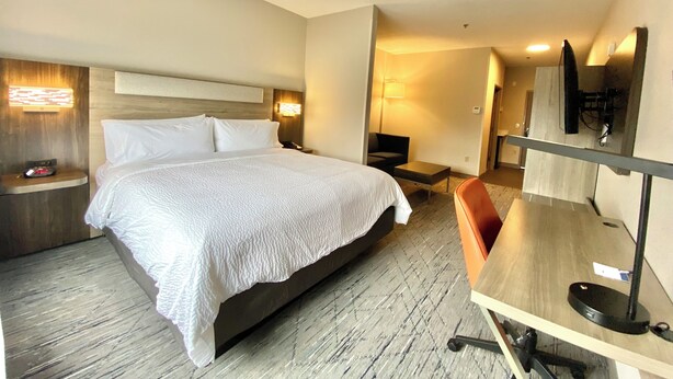 A hotel room with a large bed, bedside tables, a desk with a chair, a flat-screen TV, and a lamp. - Holiday Inn Express & Suites Elyria by IHG (Elyria)