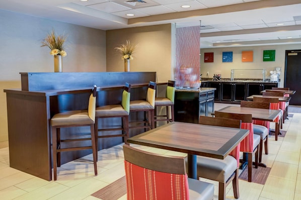 A restaurant with booths and tables, a bar area, and a counter. - Concord Suites (Concord)