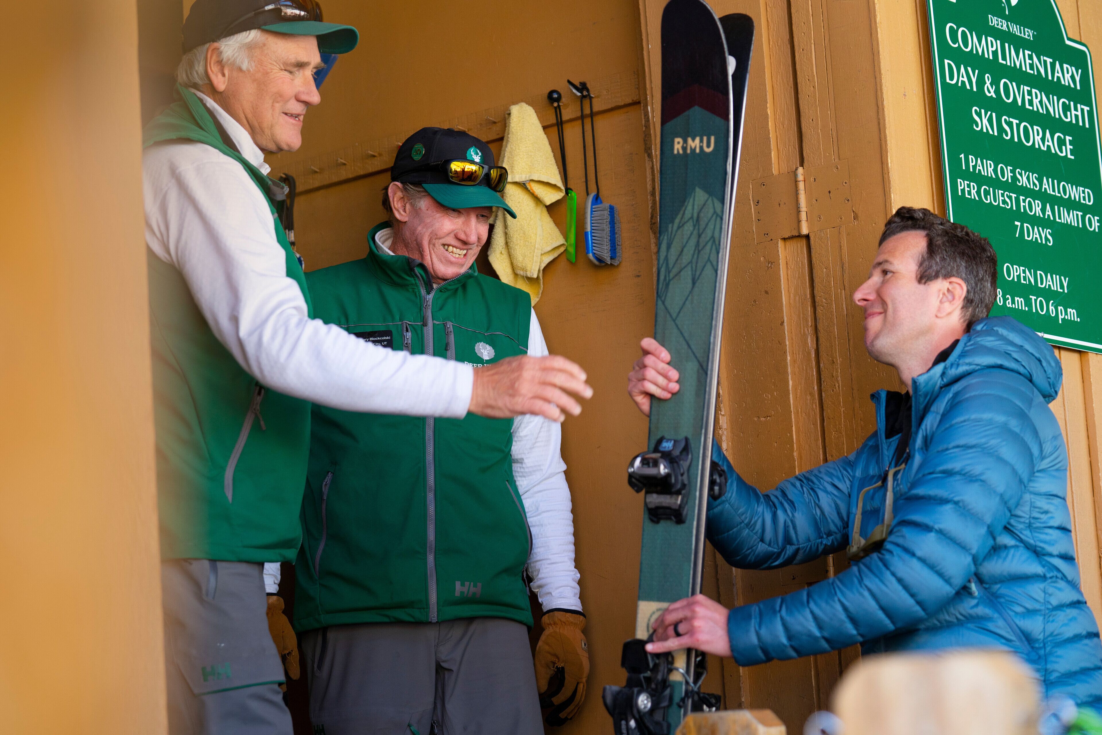 Segnaletica per deposito sci, con un paio di sci e uno snowboard.