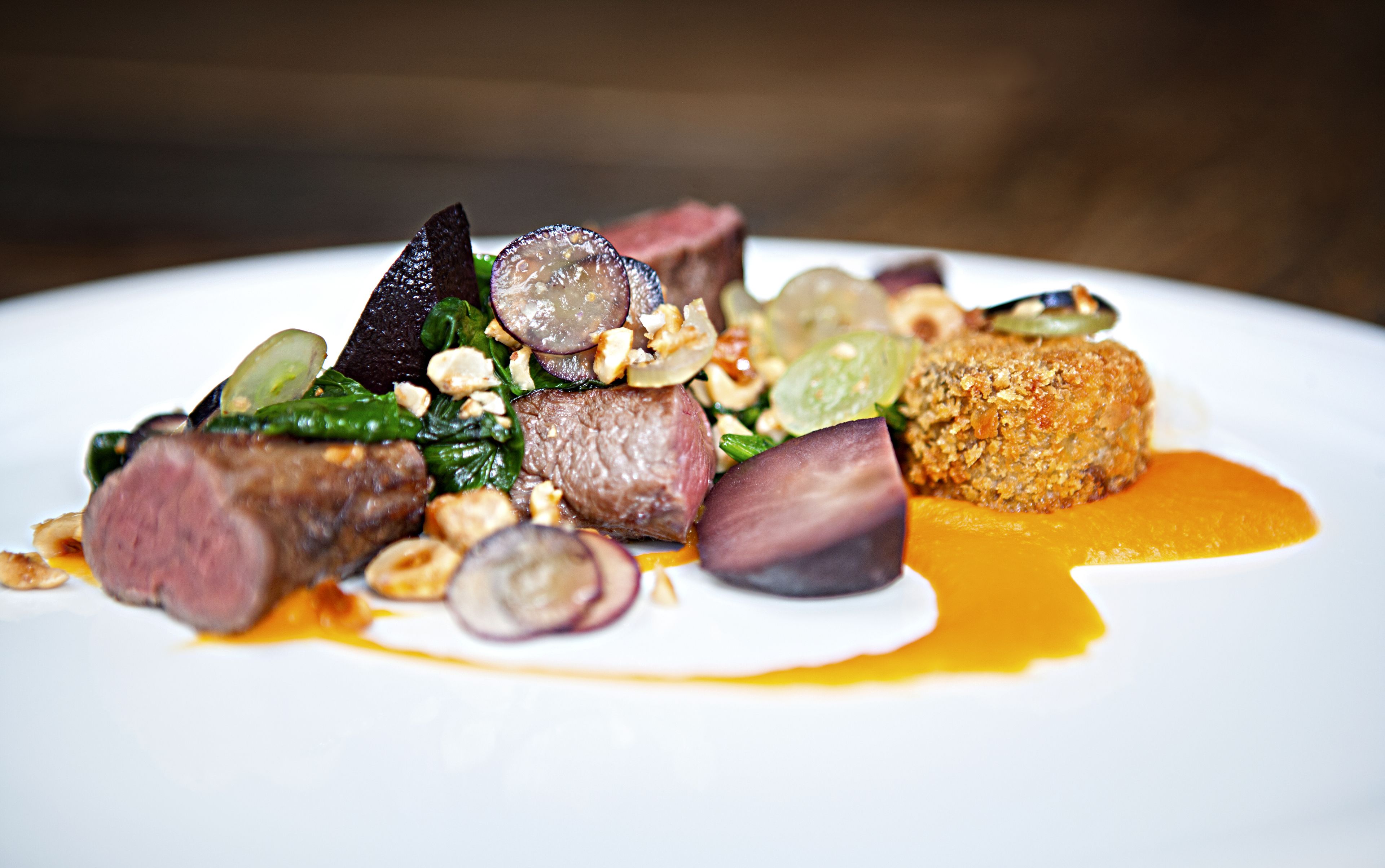 Ein angerichtetes Gericht mit verschiedenen Speisen, darunter Fleisch, Gemüse und Soße.