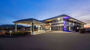 A modern hotel with a covered parking area and a well-lit entrance.