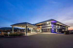 Um hotel moderno com estacionamento coberto e entrada bem iluminada.