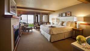 A hotel room with a large bed, a desk, a chair, and a view of the ocean. - The Ocean Lodge (Cannon Beach)