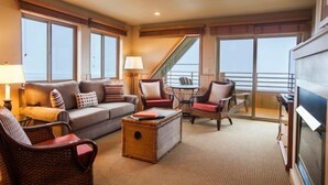 A spacious living area with a sofa, chairs, a coffee table, and a TV. - The Ocean Lodge (Cannon Beach)