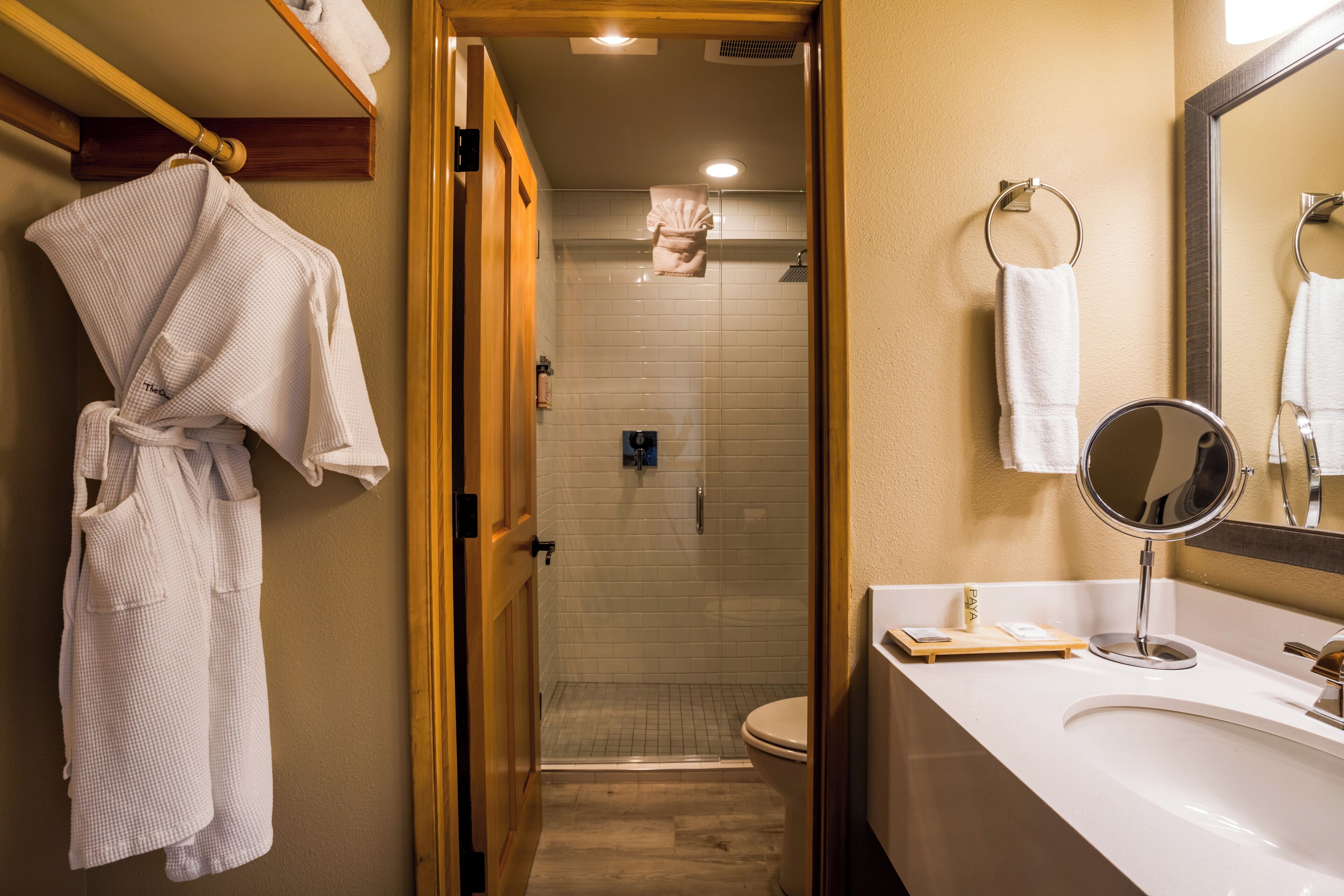 A bathroom with a white bathtub, a sink with a mirror, and a shower area.
