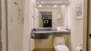 Un baño con ducha, inodoro, lavabo y toallero.