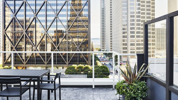 A rooftop terrace with a table and chairs, a potted plant, and a view of tall buildings. - Club Quarters Hotel Embarcadero, San Francisco (San Francisco)
