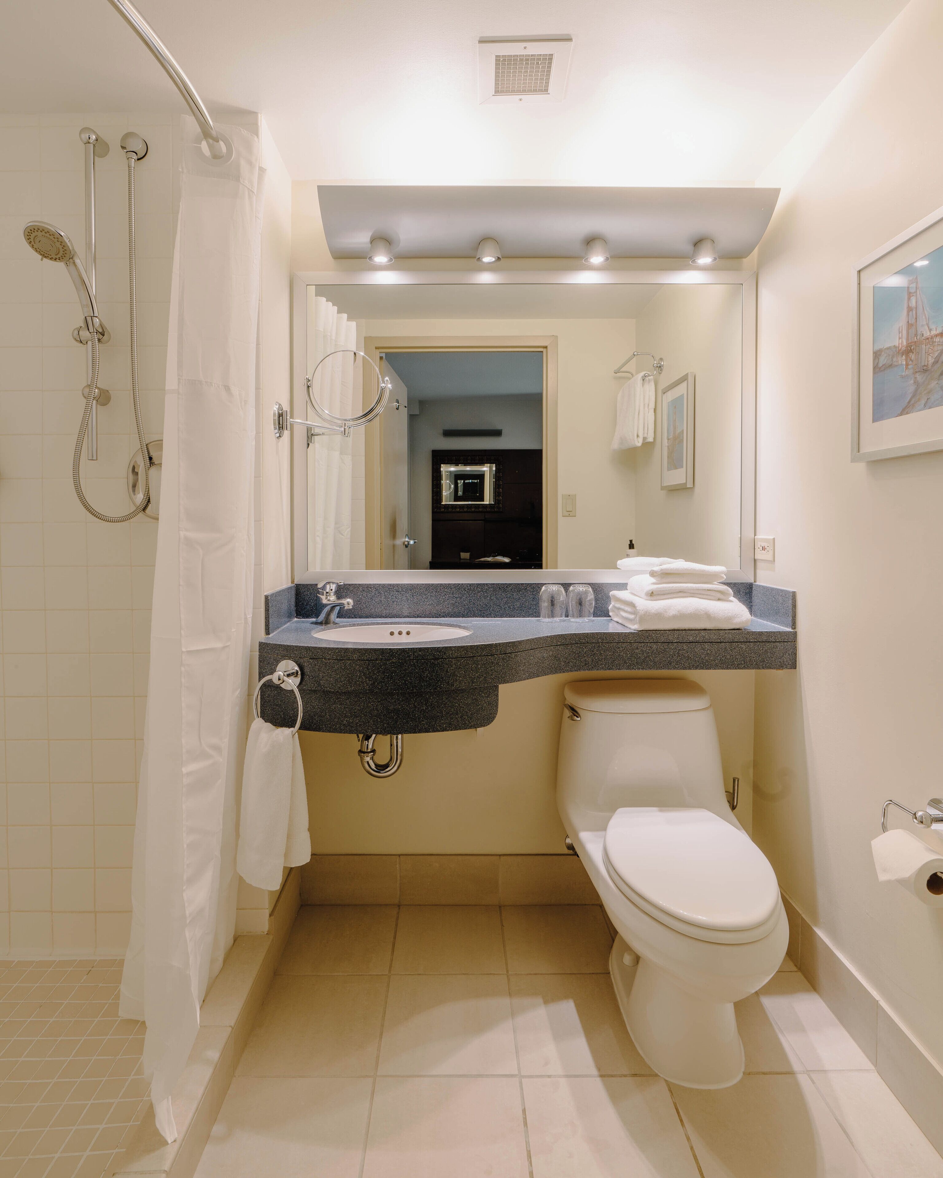 A bathroom with a shower, toilet, and sink.