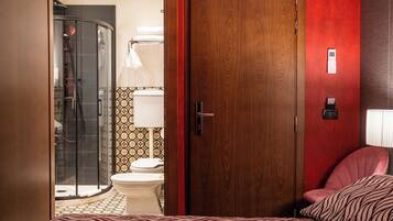 Une chambre d’hôtel avec douche, toilettes et lit.