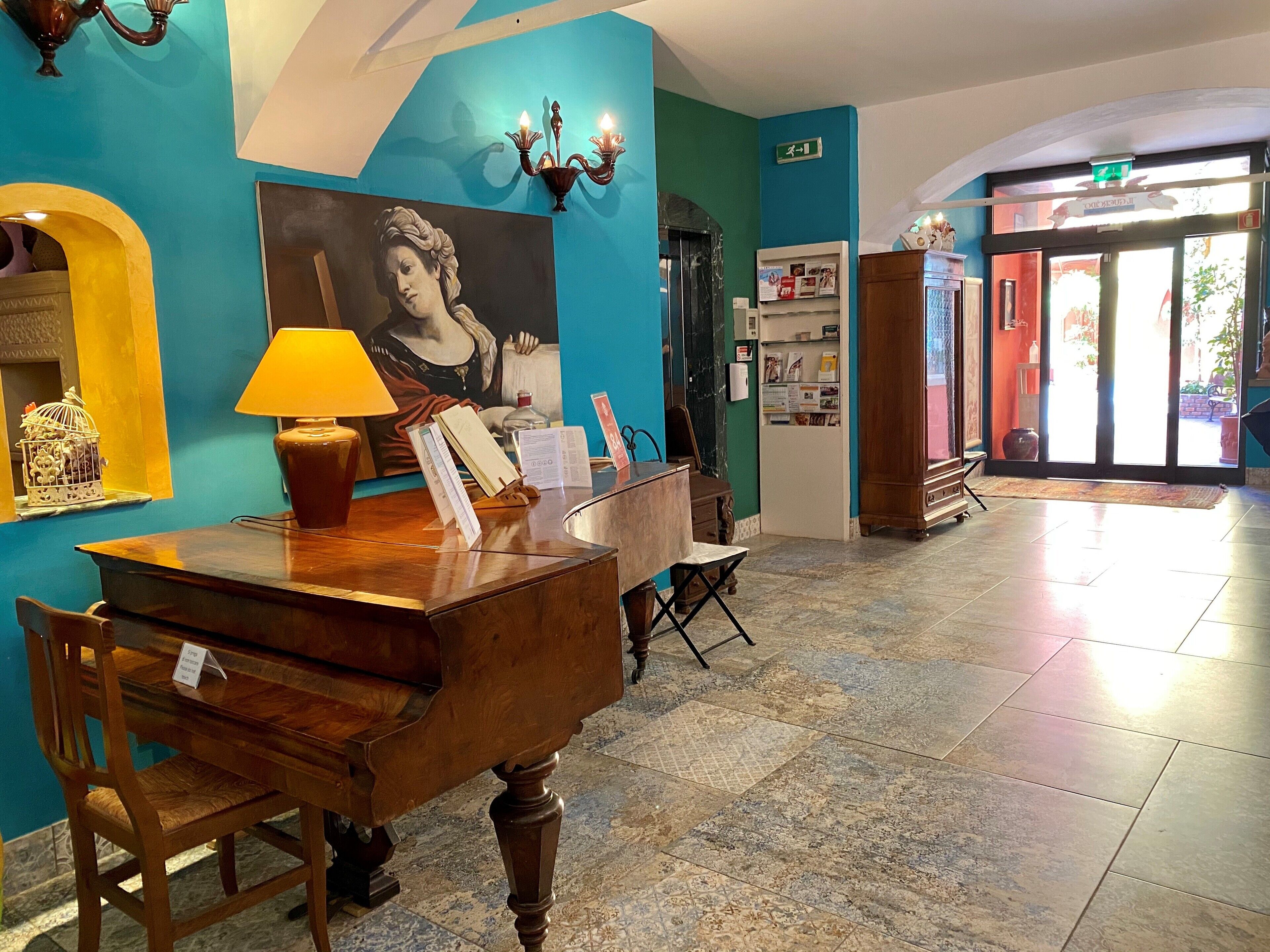 A reception desk with a lamp, a painting, and a blue wall with a number sign.