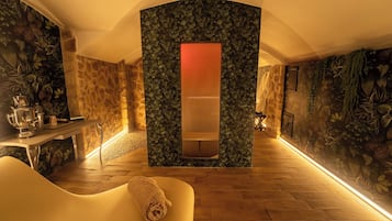 Experience ultimate relaxation in this serene spa room, featuring a soothing atmosphere, plush seating, and a tranquil green oasis.