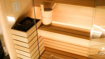 Una sauna con panche in legno, un tavolino e un catino.
