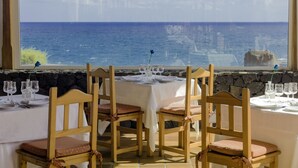 A table set for four with a view of the sea and a stone wall. - H10 Taburiente Playa (Brena Baja)