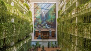 A multi-level atrium with a central garden, glass ceiling, and lush vertical gardens. - H10 Taburiente Playa (Brena Baja)
