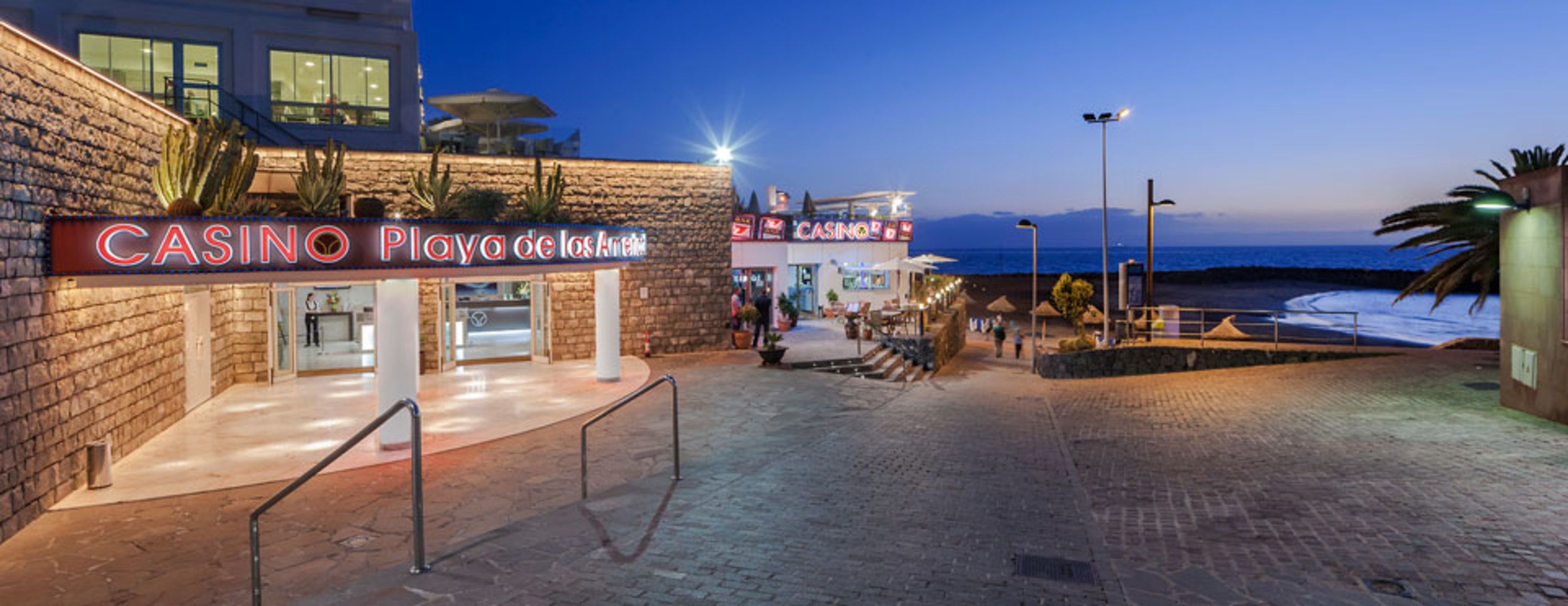 A casino with a stone facade and a beach view.