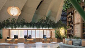 A spacious lobby with a reception desk, seating area, and a large bookshelf.
