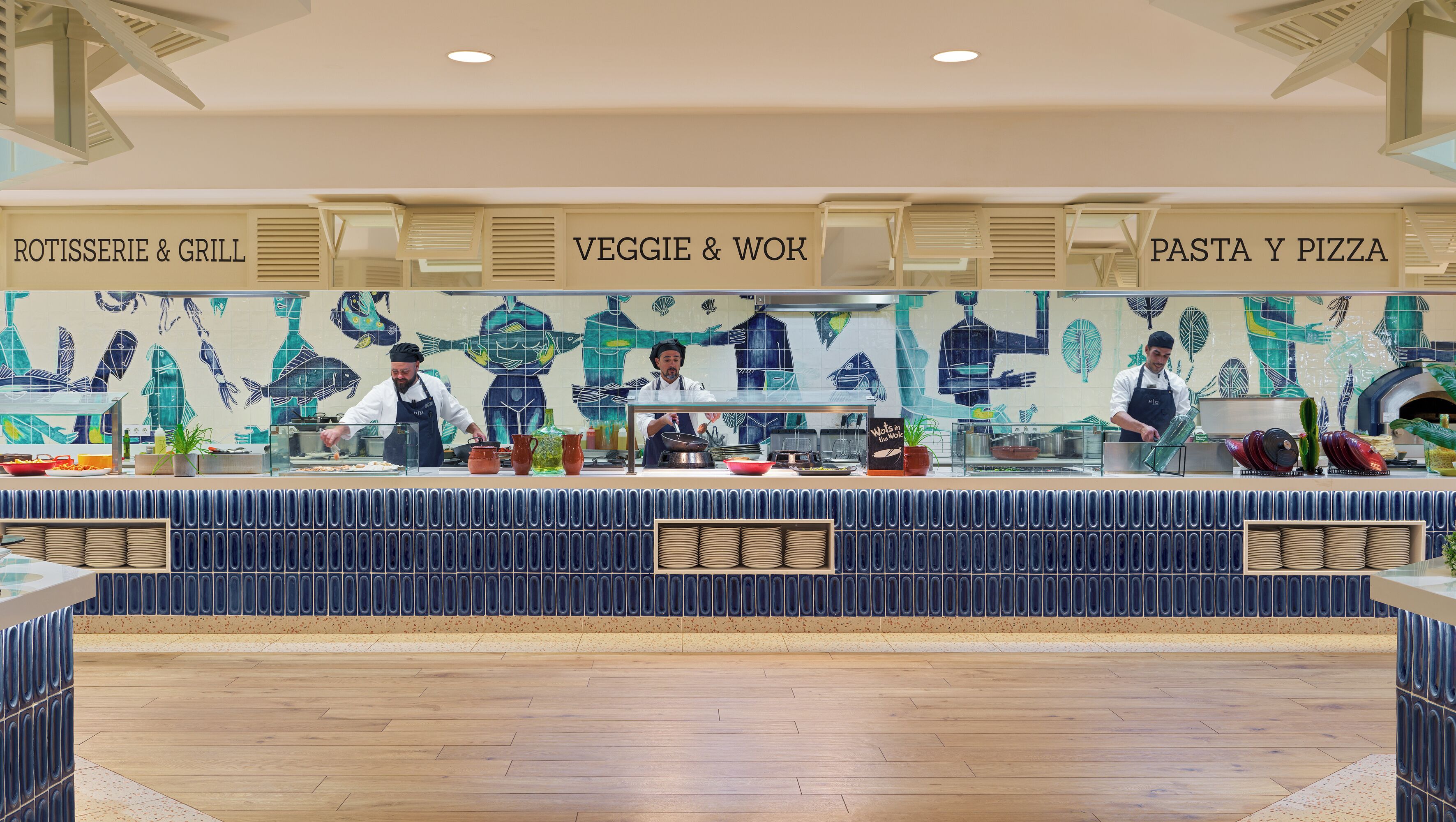 A restaurant counter with three sections labeled 'ROTISSERIE & GRILL,' 'VEGGIE & WOK,' and 'PASTA & PIZZA.'