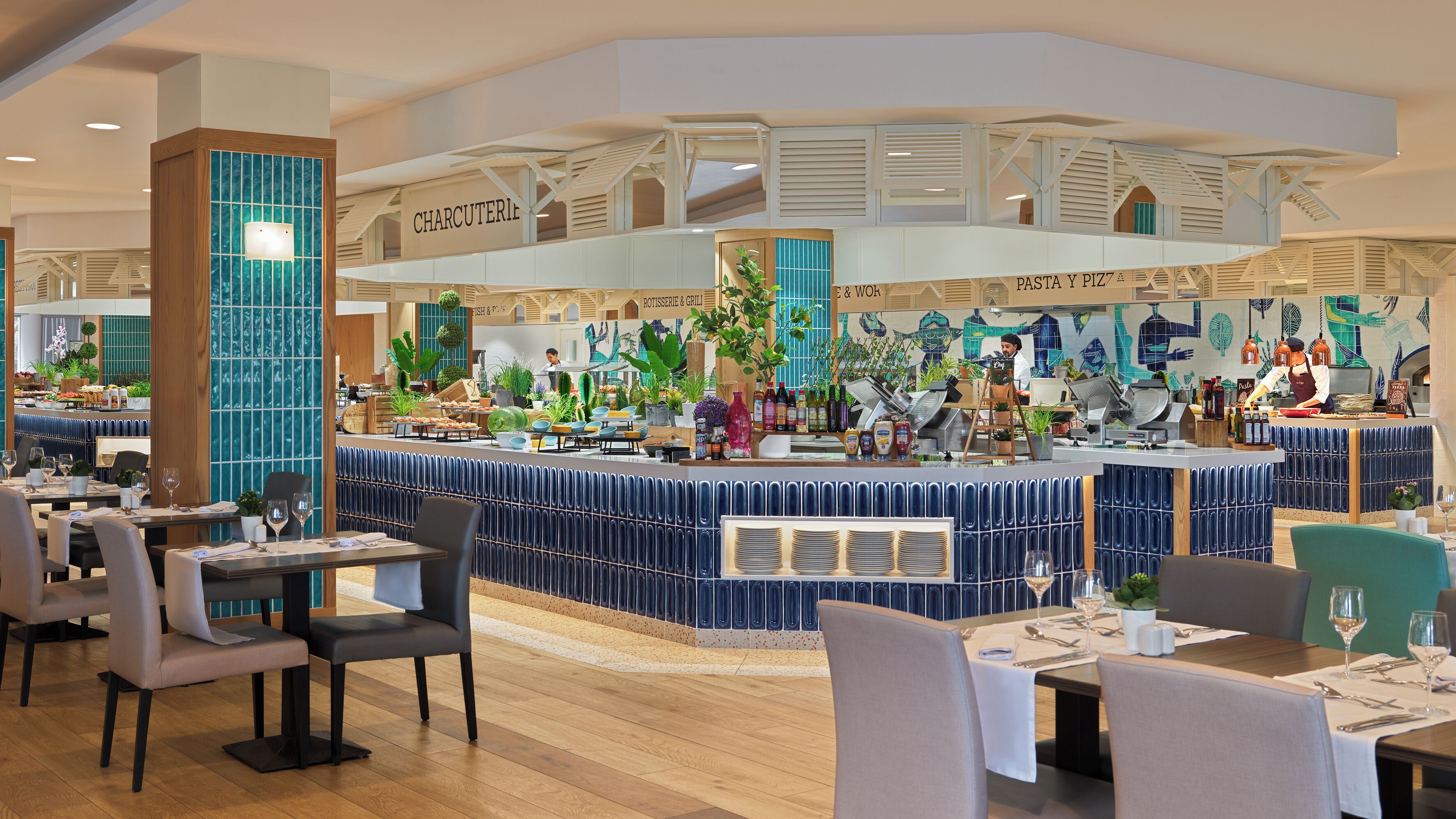 A restaurant with a central counter, multiple seating areas, and a variety of plants and food items displayed.