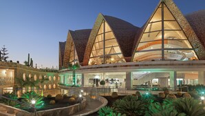 A modern hotel with a unique architectural design featuring triangular roofs and large windows.