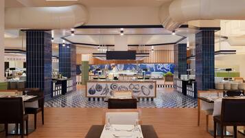 A modern restaurant with a central counter, dining tables, and a patterned floor.