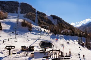 Een liftstation met een stoeltjeslift, een skipushout en een berg op de achtergrond.