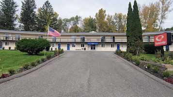 A motel with a flag in front, a sign for EconoLodge, and a well-maintained lawn.