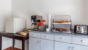 A kitchenette with a refrigerator, coffee maker, toaster, and bread display. - Econo Lodge Lee - Great Barrington (Lee)