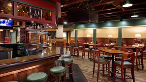 A restaurant with a bar area, multiple seating options including booths and tables, and a television mounted on the wall. - Lake Okoboji Resort & Conference Center (Okoboji)