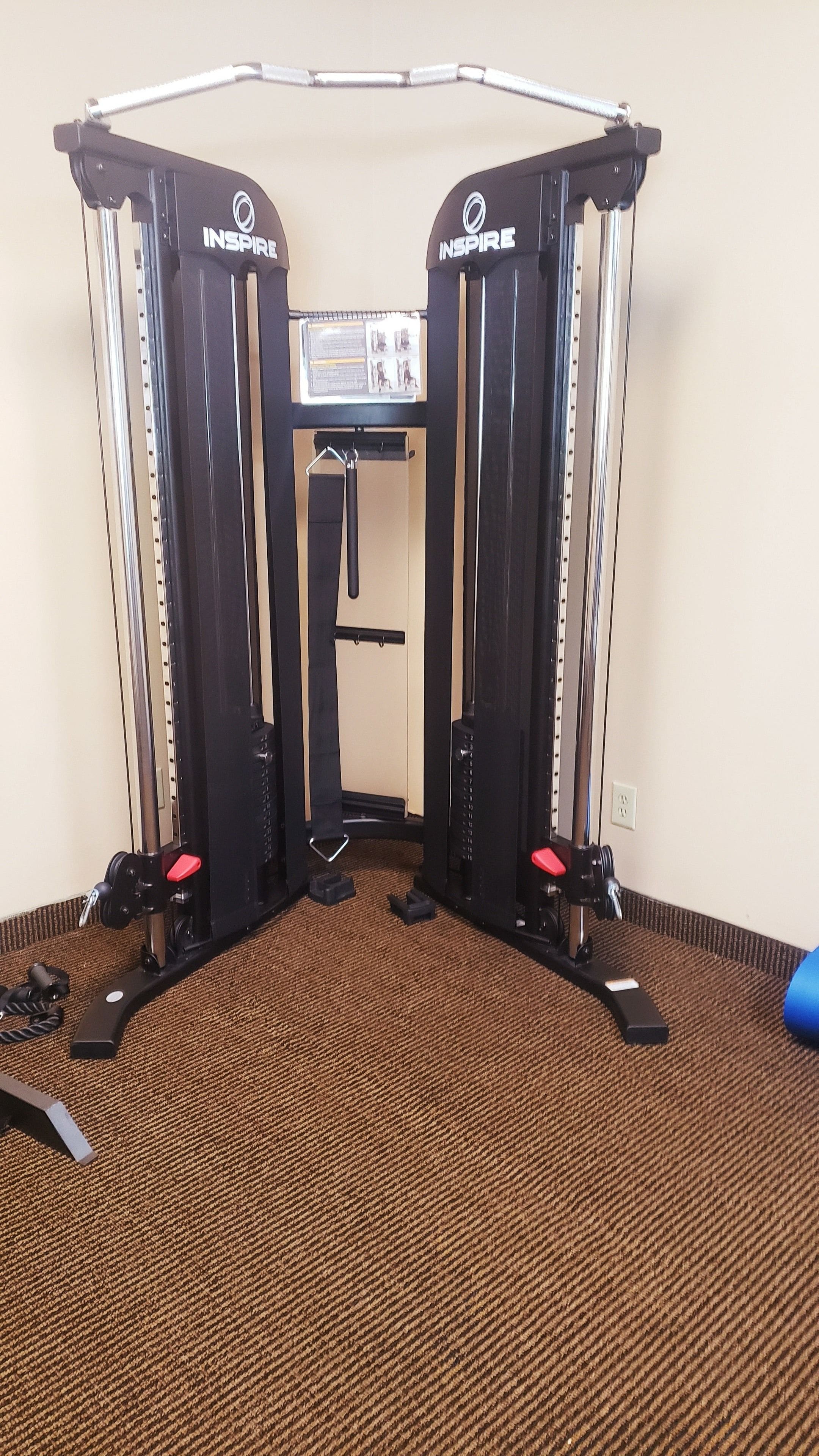 A gym with a pull-up bar, weight stack, and resistance bands.