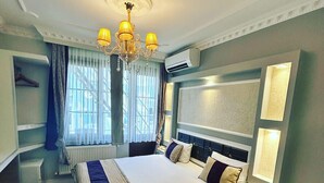 A hotel room with a large bed, a chandelier, an air conditioning unit, and a view of the outdoors through the window. - Bakirkoy Tashan Business & Airport Hotel (Istanbul)