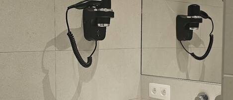 A modern bathroom with a white sink, a towel rack, and a mirror.