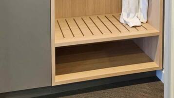 Un dressing avec une étagère en bois et un porte-manteau.