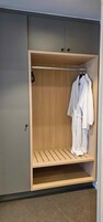 Un vestidor con un estante de madera y una percha.