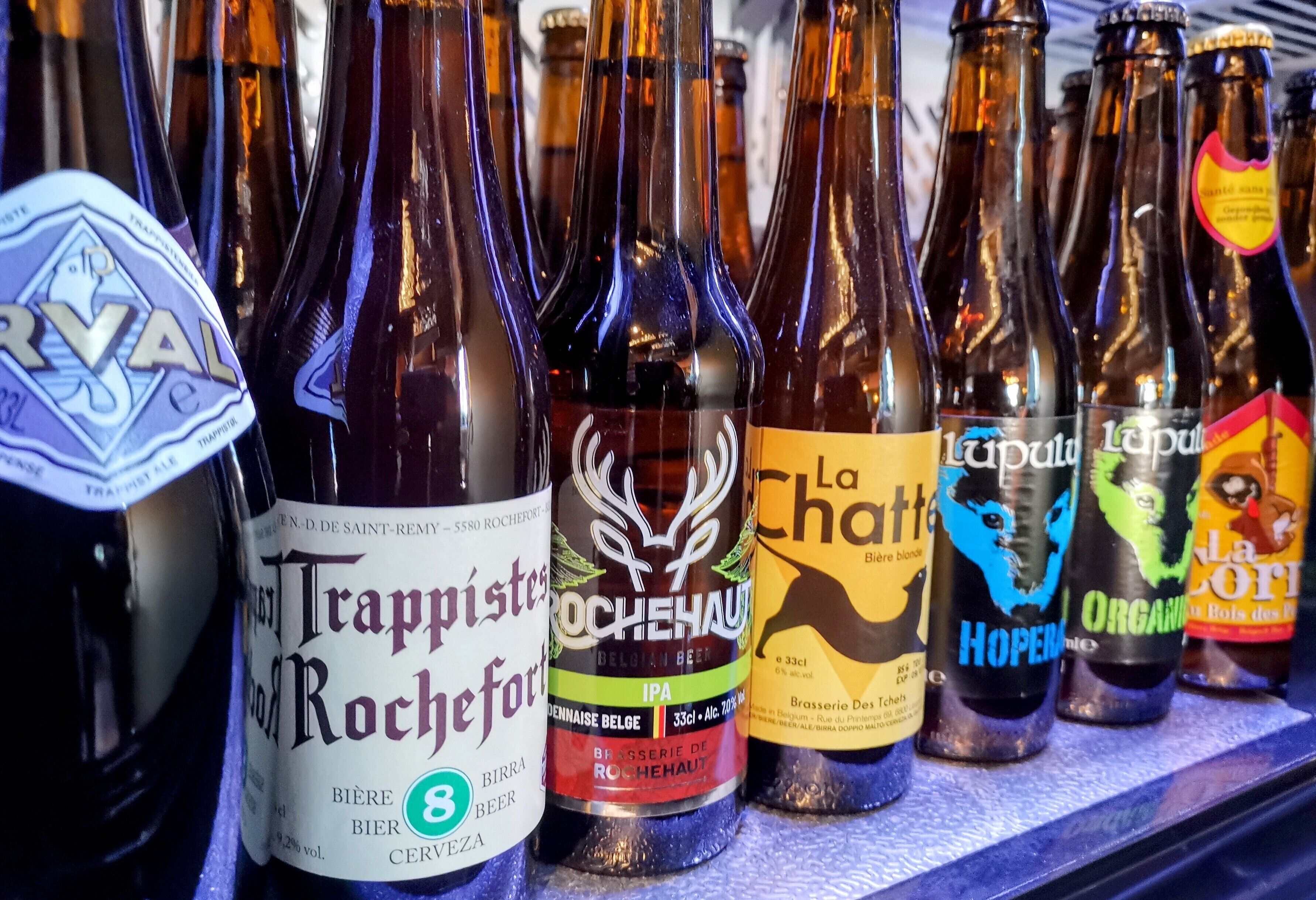 Varias botellas de cerveza con etiquetas, incluyendo marcas como Trappistes Rochefort y Rochehaut IPA.
