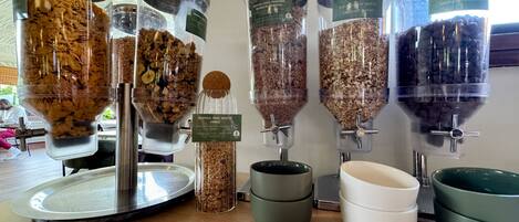Una estación de dispensado de alimentos con varias opciones de granola y cereales.