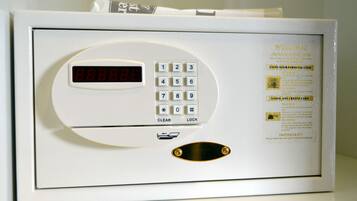 Ein weißes elektronisches Gerät mit Tastenfeld, Digitalanzeige und einer kleinen Schlitze, vermutlich ein Zutrittssystem für Hotelzimmer.
