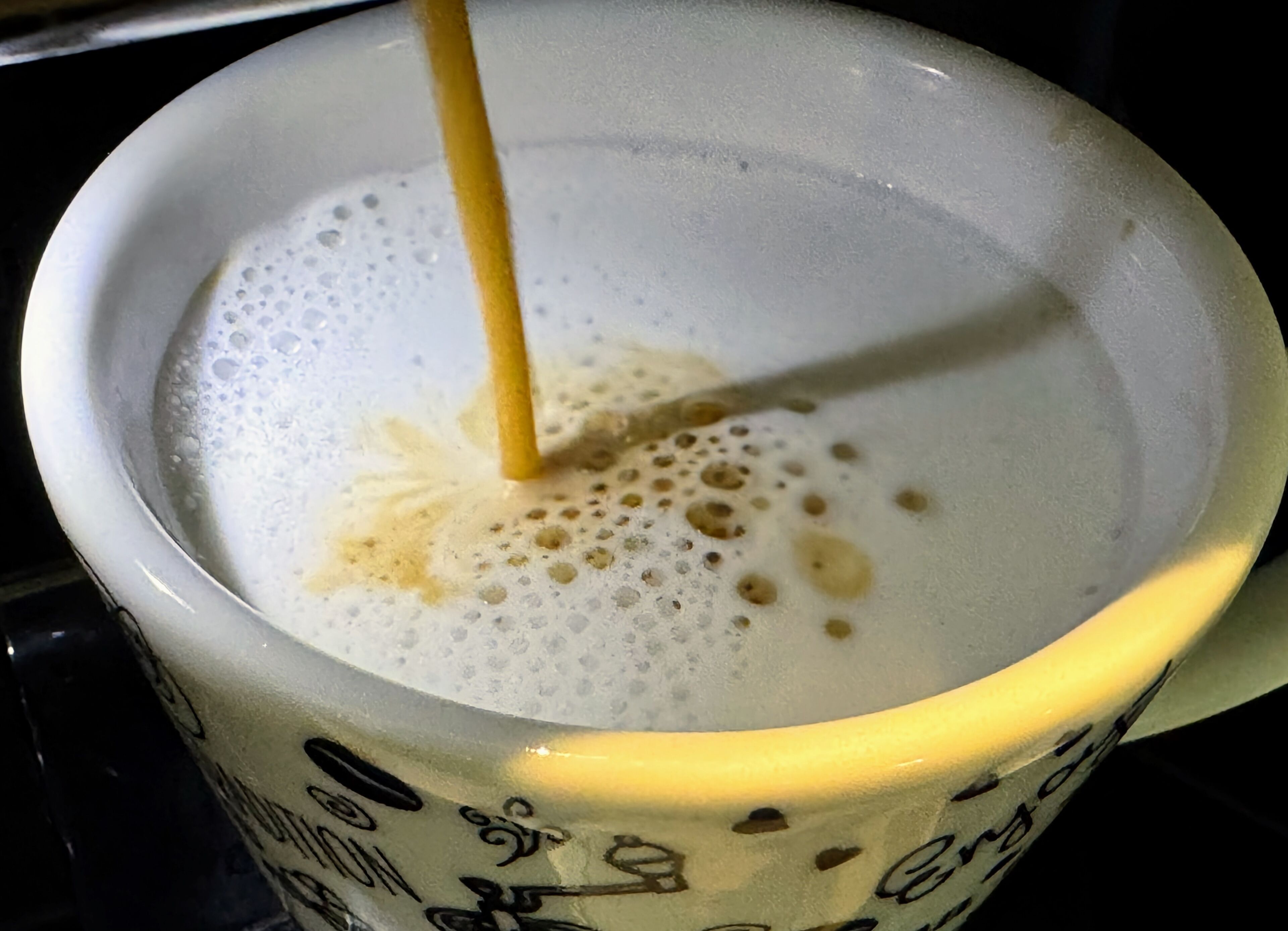 Una taza con una bebida espumosa y una pajita.