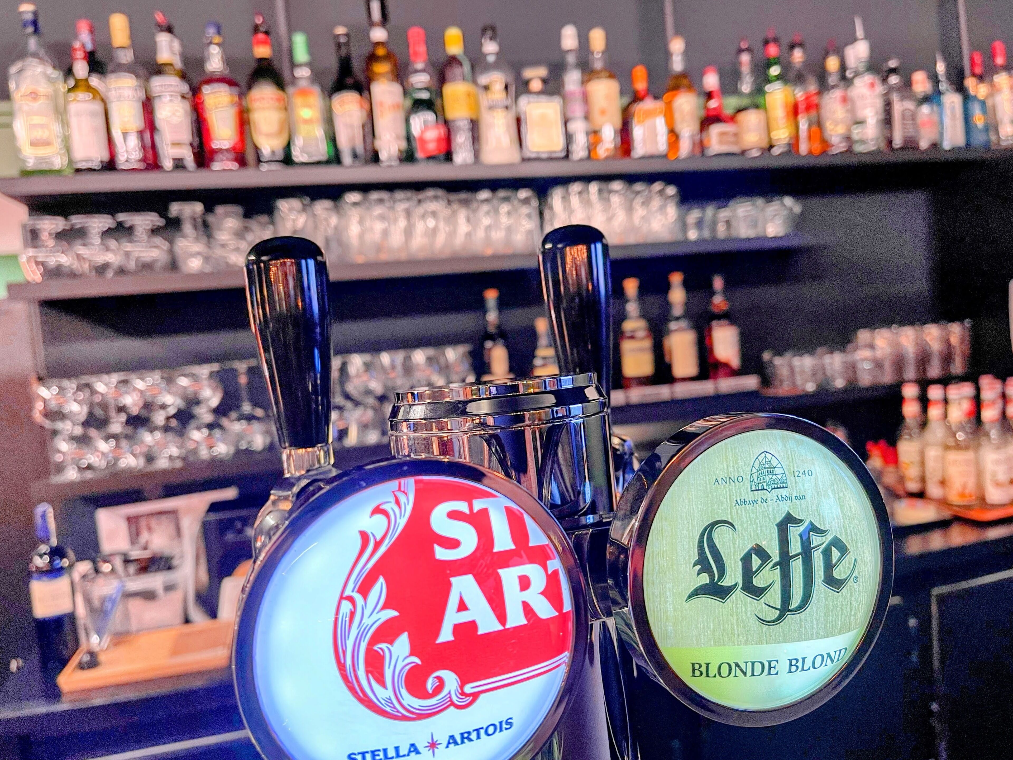 Una barra con dos grifos, uno con la indicación 'Stella Artois' y otro con la indicación 'Leffe Blonde Blond'.
