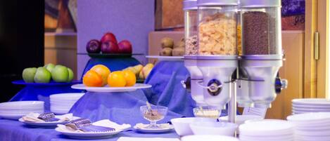 A buffet setup with various fruits, bowls, and a coffee machine.
