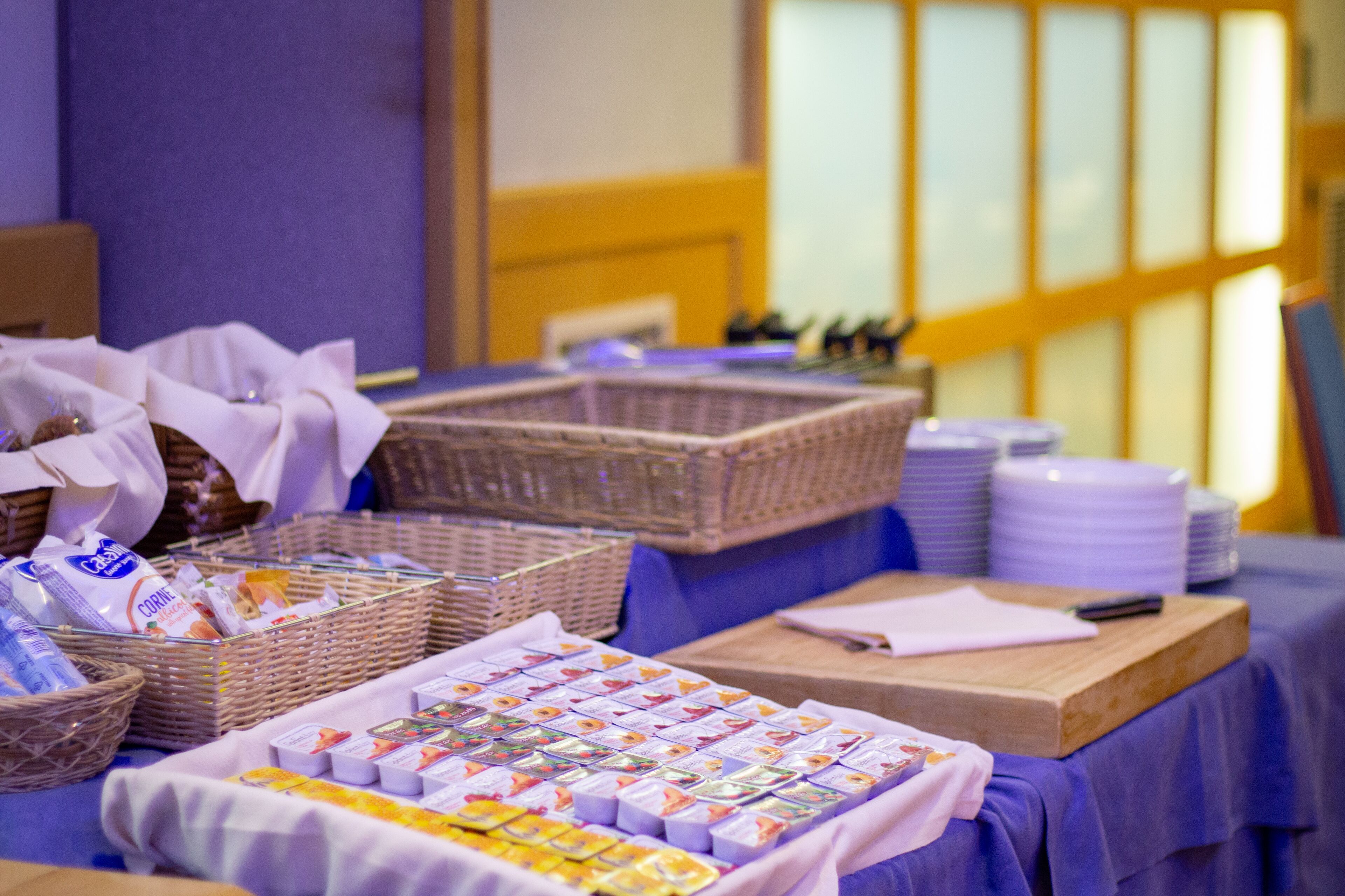 A table with baskets and packaged goods, likely for a buffet or catering service.