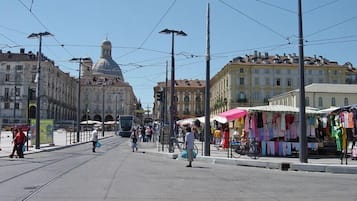 Eine Straße mit Straßenbahnschienen, einer Straßenbahn und Fußgängern.