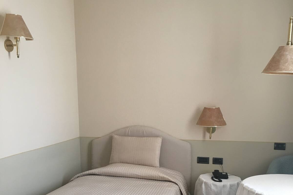 A bedroom with a bed, bedside tables, and a small round table.